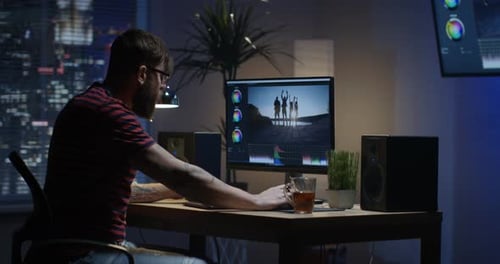 Joven sentado y editando Vídeo dentro de una habitación