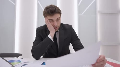 Stressed Young Adult Man with Financial Documents
