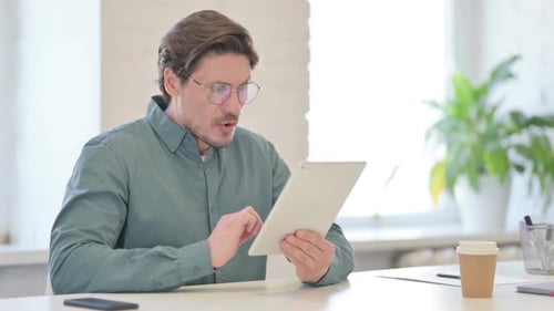 Man with Tablet Looks Surprised in Modern Office