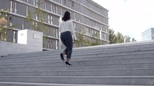 Woman Walking Up Outdoor Stairs in an Urban Setting