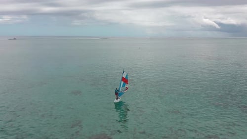Aerial View of Windsurfer Surfing in in Calm Deep Blue of Sea Extreme Summer Sport Activity
