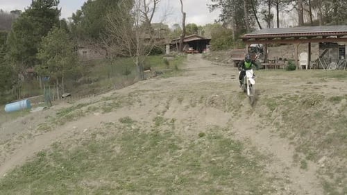 Motorbike Rider Jumps in a Sunny, Rural Setting