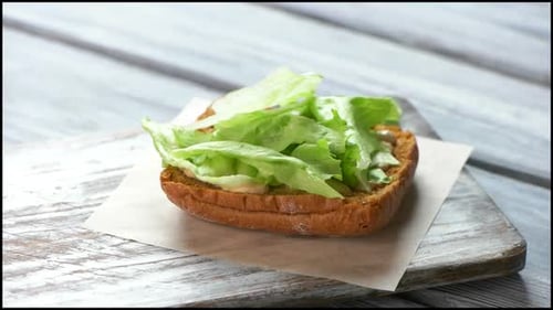 Sandwich Preparation with Steak, Lettuce, and Onion