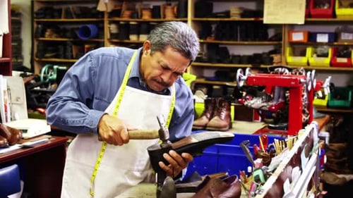 Cobbler Repairs Shoe in traditional Workshop