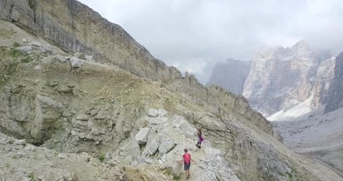 Aerial drone view of a man and woman couple hiking in the mountains.