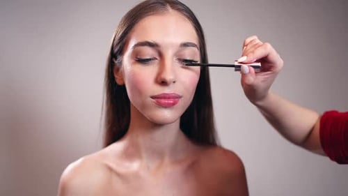 Girl Putting Mascara on Eyelashes