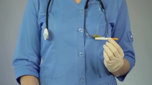 Krankenpfleger hält ein Stoppschild und eine Zigarette, verhindert ungesunden Lebensstil