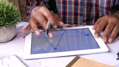 Businessman Working on Digital Tablet on Office Desk, Using Self Created Chart
