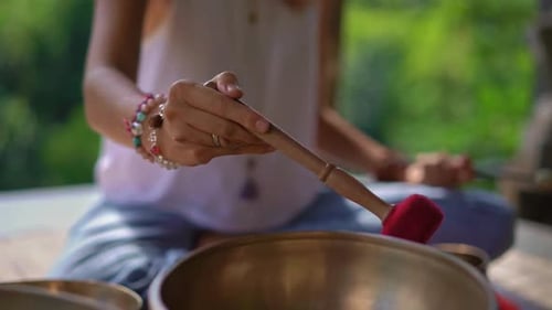 Woman Plays Singing Bowl in Tranquil, Natural Setting
