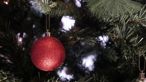 Close-up of glittering surface ornament on Christmas tree 4K 2160p 30fps UltraHD footage - Red colo