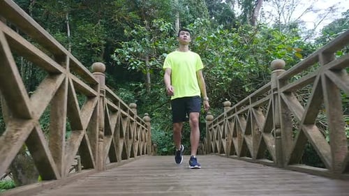 Asian Man Walking On Bridge