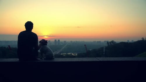 A Man Caresses His Dog While Enjoying the View
