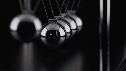 Die Kugeln einer Newtons Cradle kollidieren in Zeitlupe