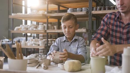 Child and Adult Working with Clay in Pottery Studio