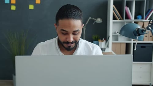 Portrait of Attractive African American Man Working with Computer Typing in Modern Office