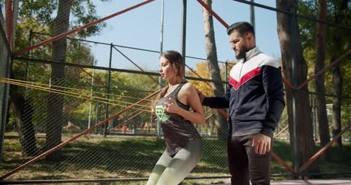 Woman Training with Resistance Band in Outdoor Park