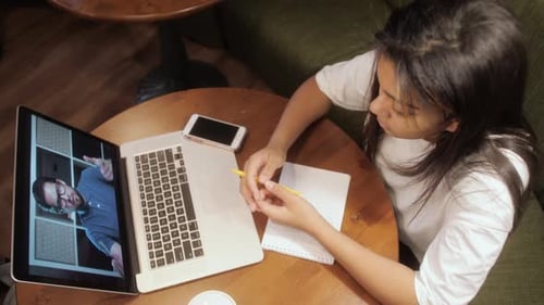 Étudiante de jeune fille regardant la leçon en ligne et étudiant à la maison