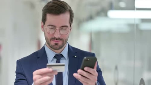 Young Businessman Making Online Payment on Smartphone