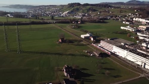 Aerial panning shot of passing swiss train and beautiful landscape shot in background,
Hills,green f
