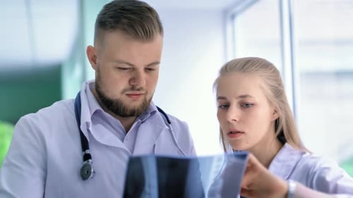 Close Up Portrait of Two Medical Specialist Discussing Xray Prints at Hospital