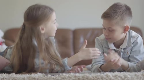 Children Chatting and Smiling on Carpet at Home