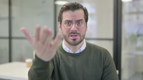 Man Speaking and Gesturing Towards the Camera
