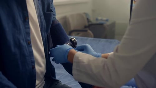 Doctor Checking Patient's Blood Pressure with Stethoscope