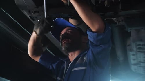 Young man is mechanic repair car in the garage with professional, auto service.