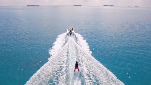 Aerial drone view of a man water skiing near a tropical island
