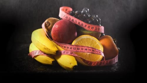 Fresh Fruit with Measuring Tape on Black Background