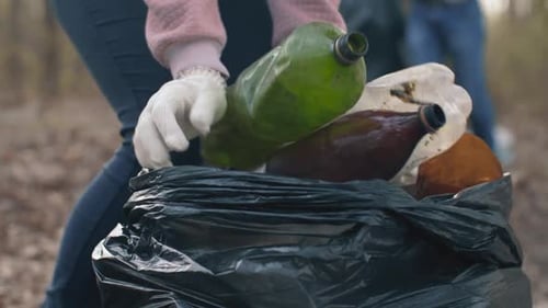 Mujer poniendo basura doméstica en una bolsa de basura