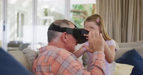 Little Girl Helping Grandfather with Virtual Reality Headset