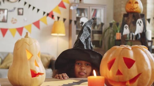 Excited Girl in Witch Hat Celebrates Halloween at Home