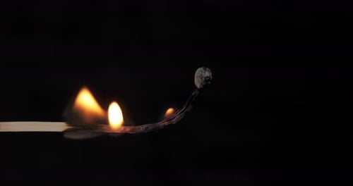Matchstick Ignites and Burns in Dark Close Up