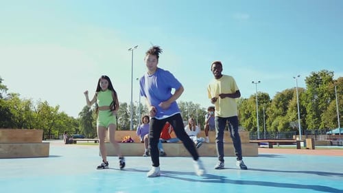 Stylish Young Adults Dancing Together in Urban Park