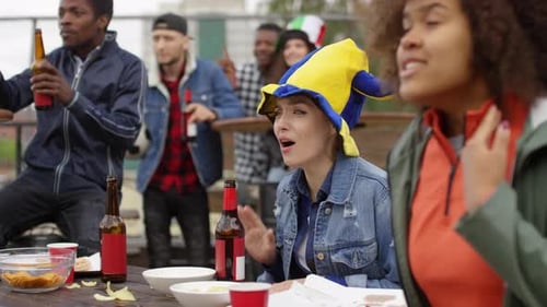 Woman Celebrating Goal while Watching Soccer with Friends in Outdoor Bar