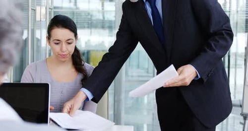 Businessman giving a document to colleague