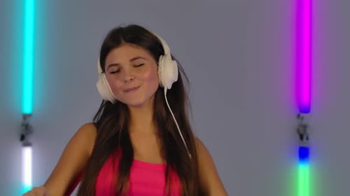 Young Woman Dancing With Headphones and Colorful Lights