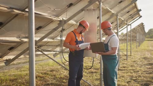 Technicians with Tablet Checking the Panels at Solar Energy Installation