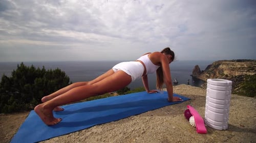 Woman Doing Yoga on Coastal Hilltop