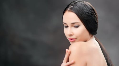 Seductive Brunette Woman Stroking Naked Body Posing at Black Studio Background Isolated