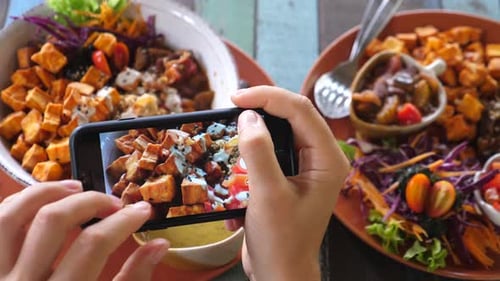 Hands Photographing Vibrant Vegan Food with Smartphone
