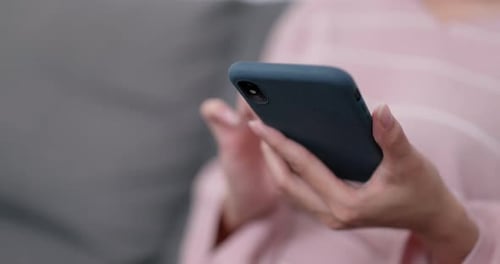 Woman Types on Blue Cell Phone at Home