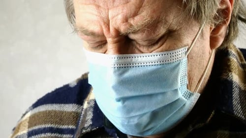 Un homme malade portant un masque médical suffoque, respire lourdement, il n'a pas assez d'oxygène