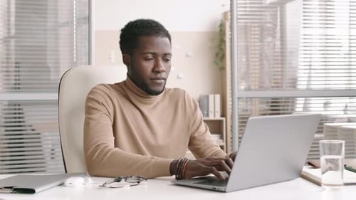 Portrait of Businessman Working on PC in Office