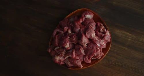 Ein Stapel von geschnittenem rohem Rindfleisch auf einem Teller dreht sich langsam.