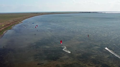 People go kitesurfing on the sea. The wind carries the athlete along the sea waves.