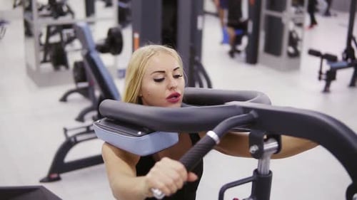 Woman Working Out on Weight Machine in Gym
