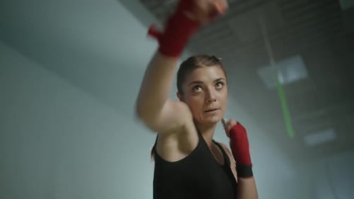 Kämpferin trainiert ihre Schläge im Boxstudio, Frau trainiert schnell eine Reihe von Schlägen