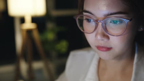 Woman with Glasses Working Late at Night